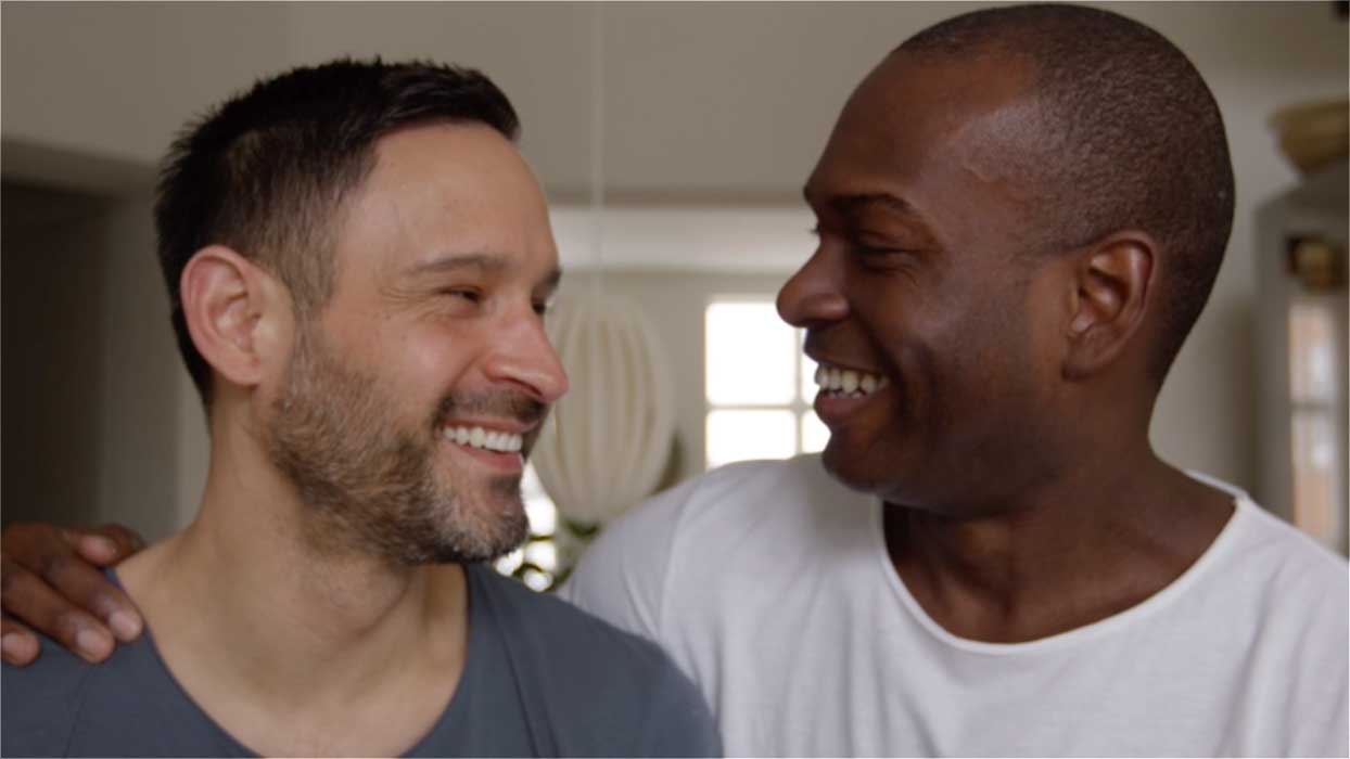 Two gay men smiling.